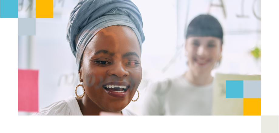 Professional with headscarf brainstorming at a glass board, discussing roles and structure.