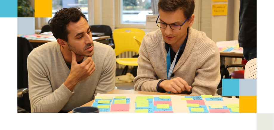 Two men discussing sticky notes